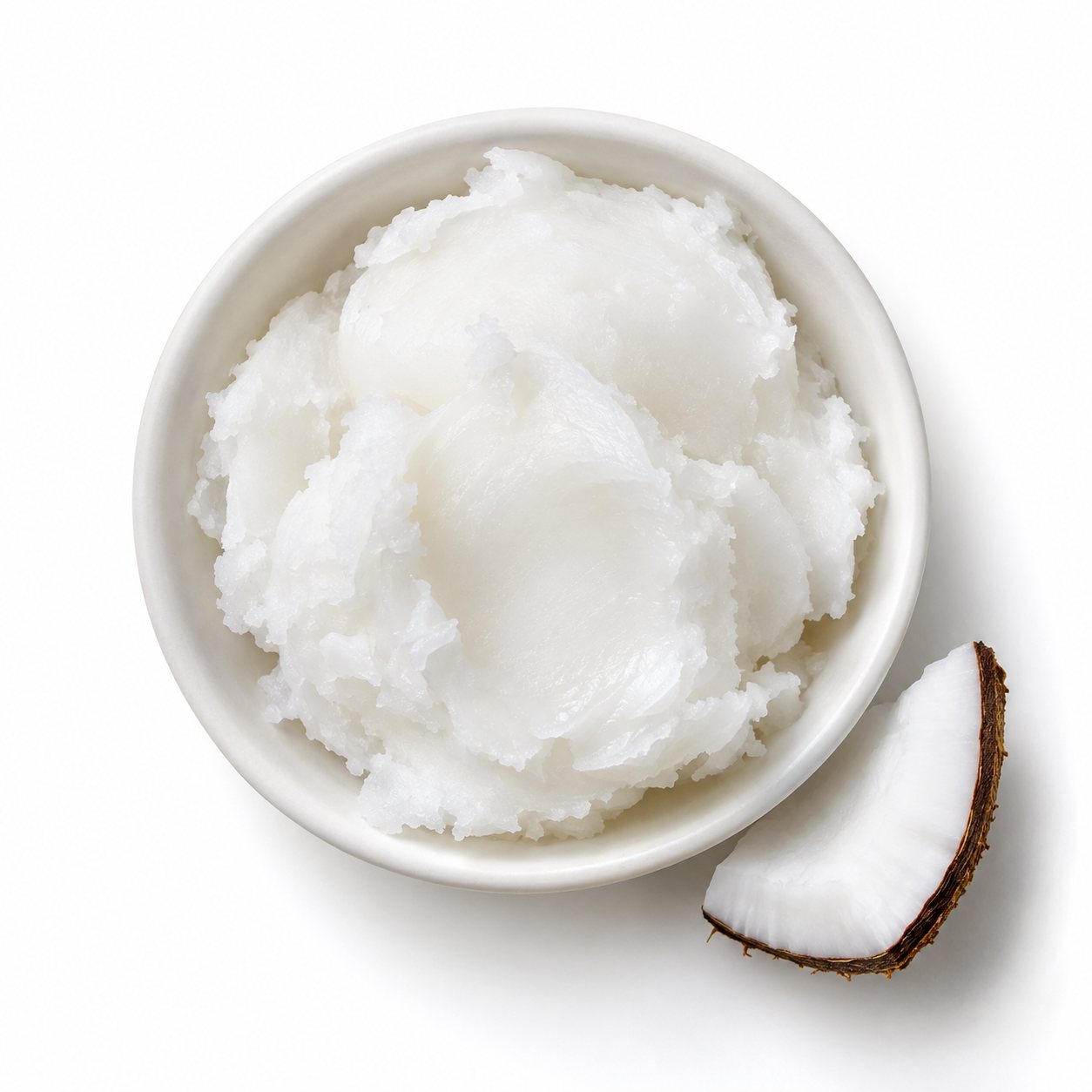 Overhead photograph of coconut oil with fresh coconut on white