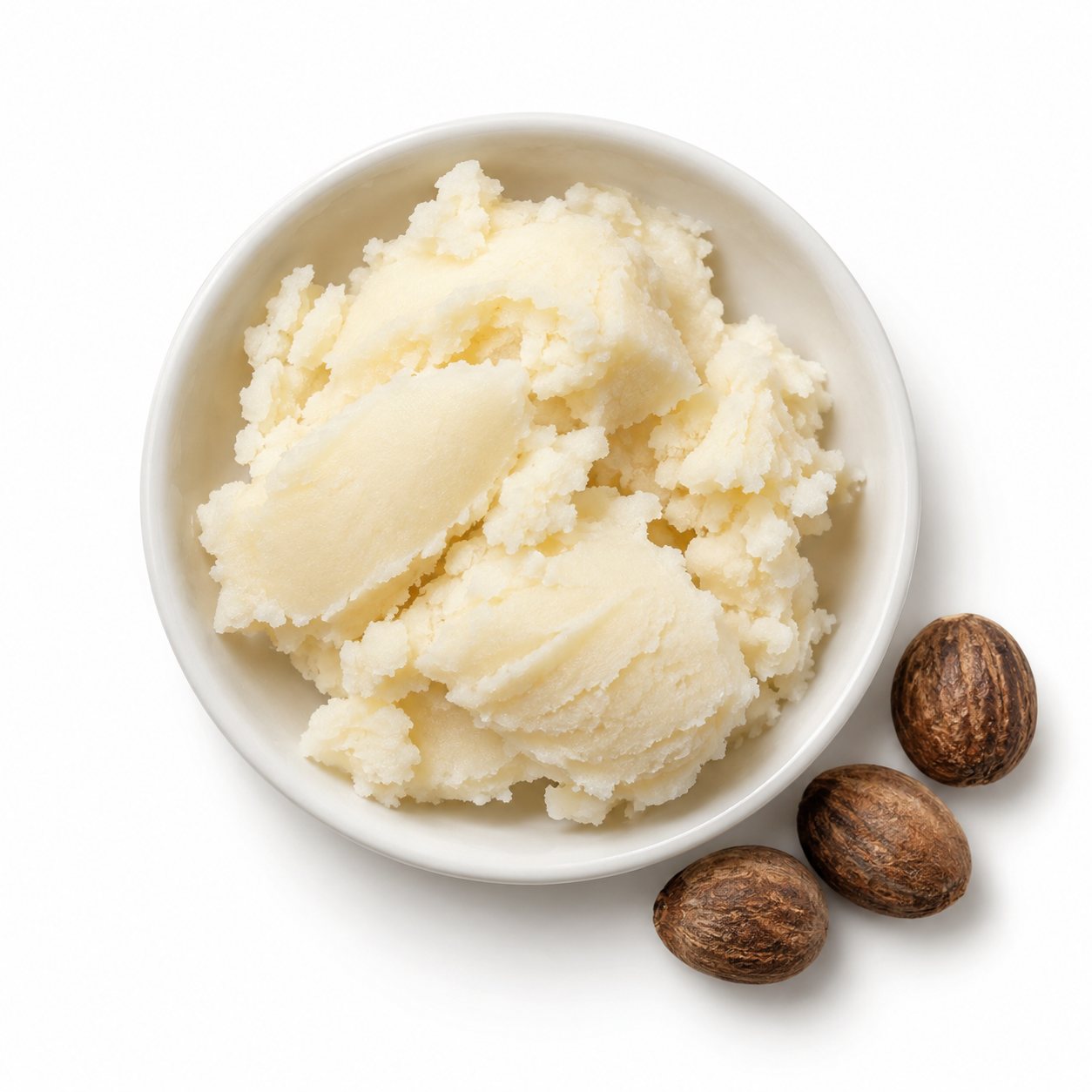 Overhead photograph of shea butter and shea nuts on white
